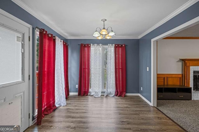 unfurnished dining area with a notable chandelier, wood-type flooring, and crown molding