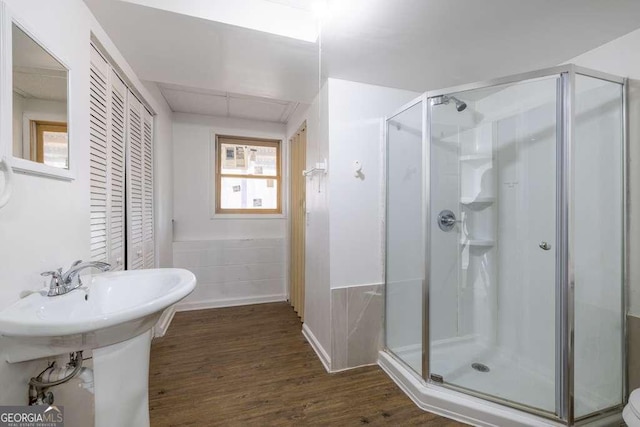 bathroom featuring hardwood / wood-style floors and a shower with shower door