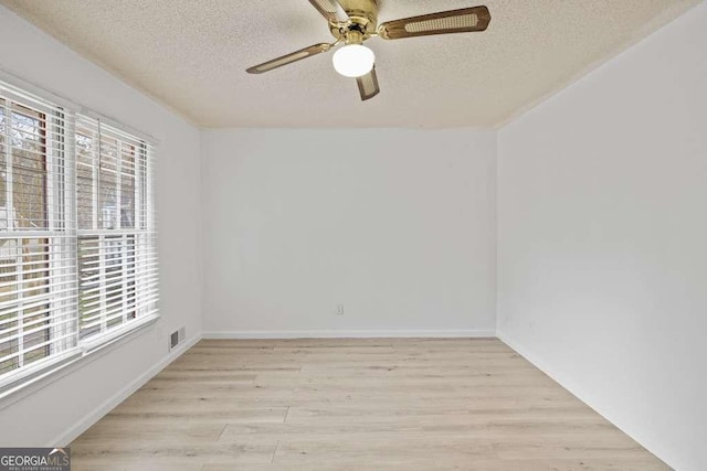 empty room with ceiling fan, light hardwood / wood-style floors, and a textured ceiling