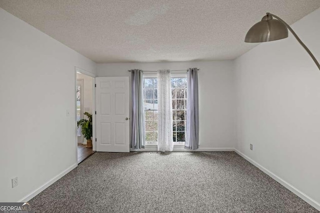 empty room with carpet flooring and a textured ceiling