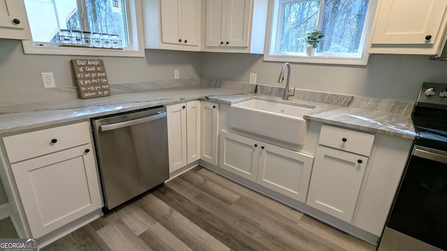 kitchen featuring appliances with stainless steel finishes, sink, white cabinets, and light stone counters