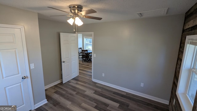 spare room featuring ceiling fan, dark hardwood / wood-style flooring, and a textured ceiling