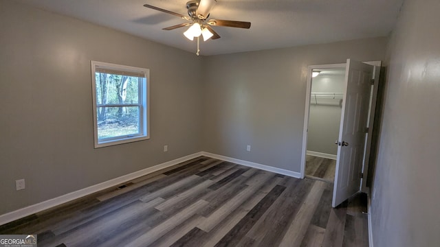 unfurnished bedroom with dark wood-type flooring, ceiling fan, and a closet