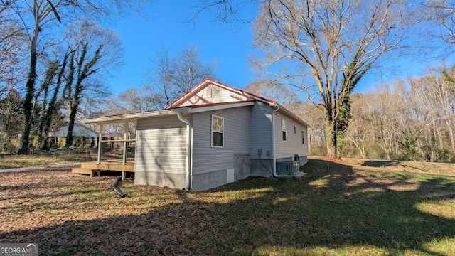 view of home's exterior with a yard and central AC