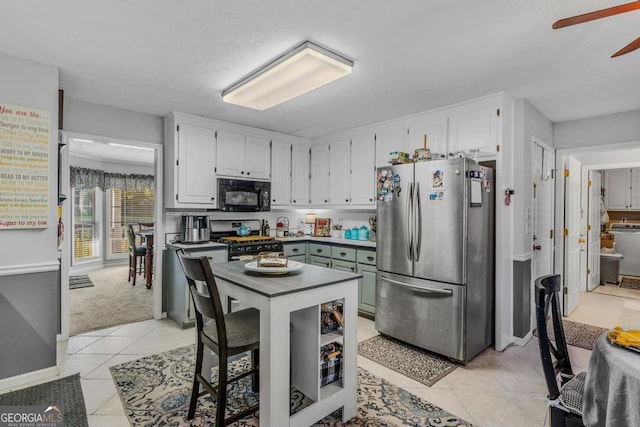 kitchen featuring ceiling fan, light tile patterned floors, white cabinetry, and appliances with stainless steel finishes