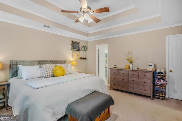 bedroom with a raised ceiling, ceiling fan, crown molding, and light colored carpet