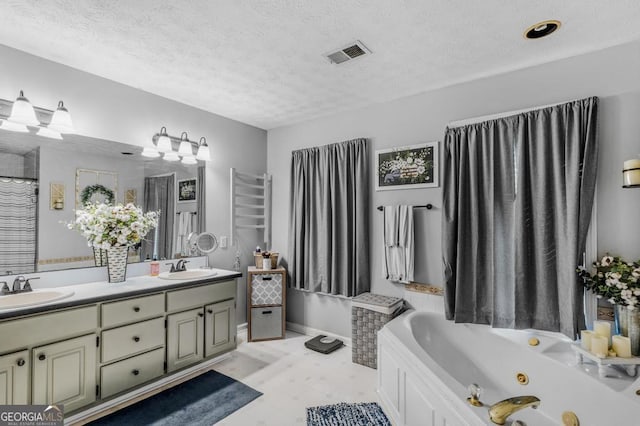 bathroom with a bathing tub, vanity, and a textured ceiling