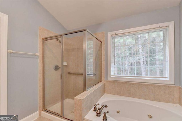 bathroom with shower with separate bathtub and vaulted ceiling