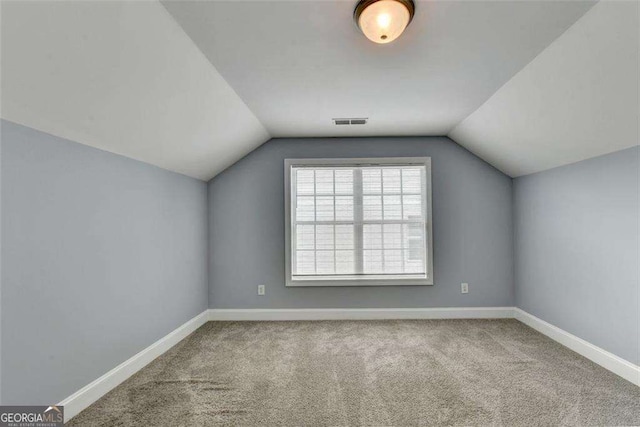 additional living space featuring carpet flooring and lofted ceiling