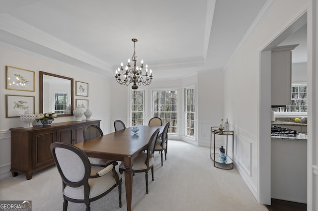 carpeted dining space featuring a notable chandelier and ornamental molding