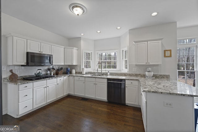 kitchen featuring kitchen peninsula, white cabinetry, and black appliances