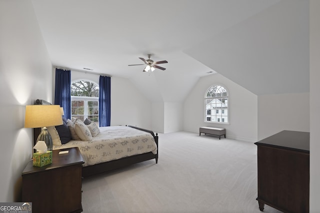 bedroom featuring multiple windows, light colored carpet, vaulted ceiling, and ceiling fan