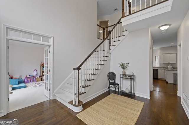 entryway with dark hardwood / wood-style flooring and crown molding