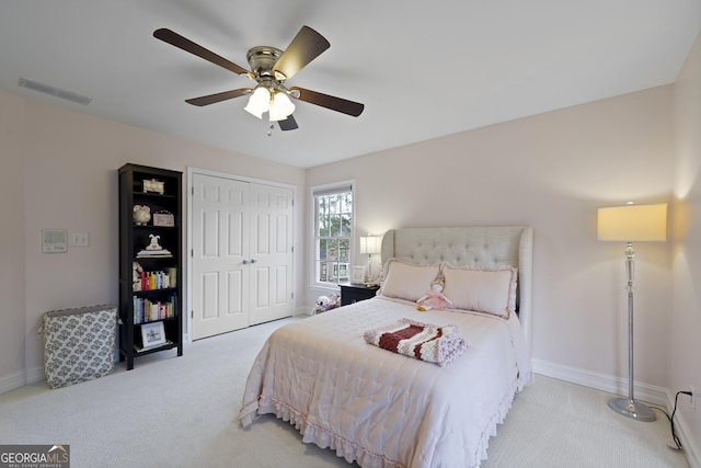 carpeted bedroom featuring ceiling fan and a closet