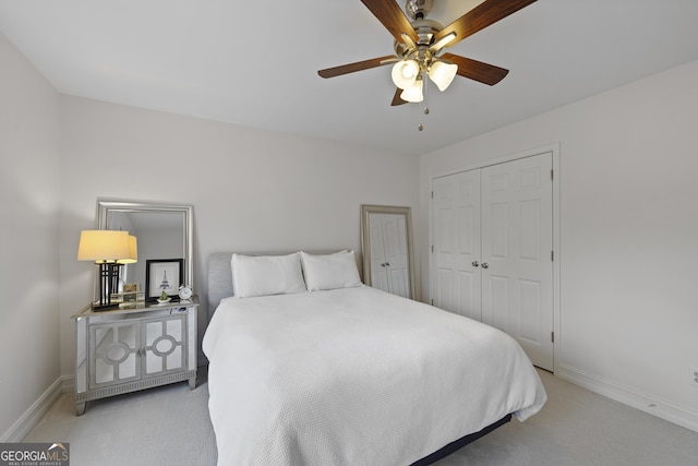 bedroom with a closet, light colored carpet, and ceiling fan