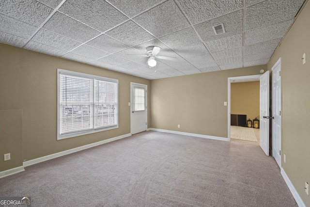 unfurnished room featuring a paneled ceiling, ceiling fan, and carpet flooring