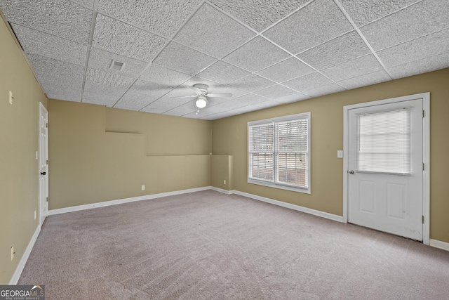 carpeted empty room featuring a drop ceiling and ceiling fan