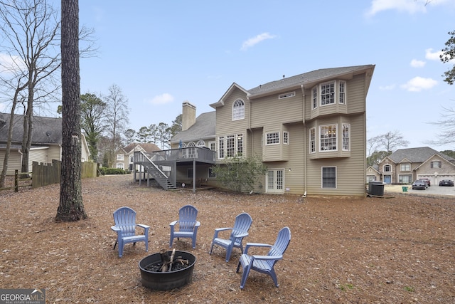 rear view of house with central air condition unit, an outdoor fire pit, and a wooden deck