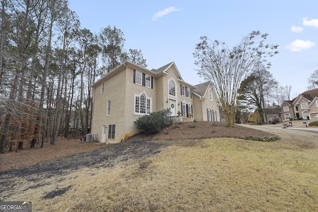 view of property exterior featuring central air condition unit and a yard