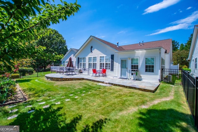 rear view of house with a patio area, a yard, and central AC