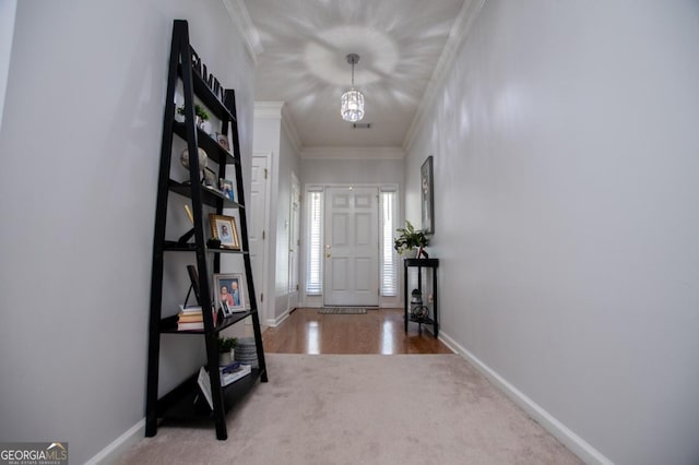 foyer featuring a notable chandelier, carpet floors, and crown molding