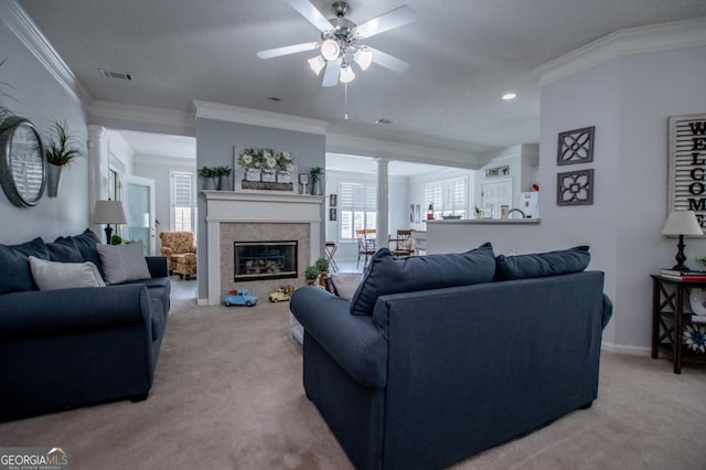 carpeted living room with a textured ceiling, ceiling fan, ornamental molding, and a fireplace