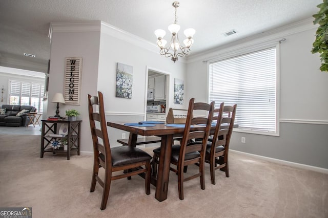 carpeted dining room with crown molding, a textured ceiling, and an inviting chandelier