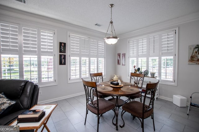 tiled dining area featuring a textured ceiling and plenty of natural light