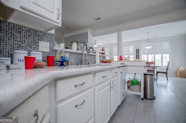 kitchen featuring decorative backsplash, ornamental molding, dishwasher, white cabinets, and hanging light fixtures