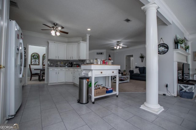 kitchen with white cabinets, white fridge, decorative columns, and ceiling fan