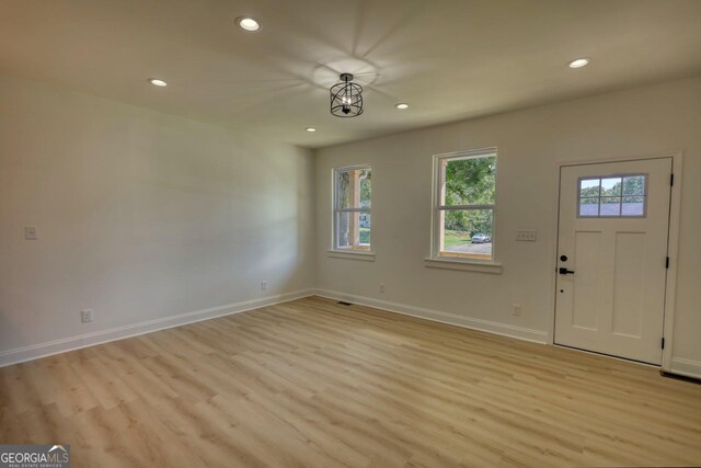 foyer entrance with light hardwood / wood-style floors and a notable chandelier