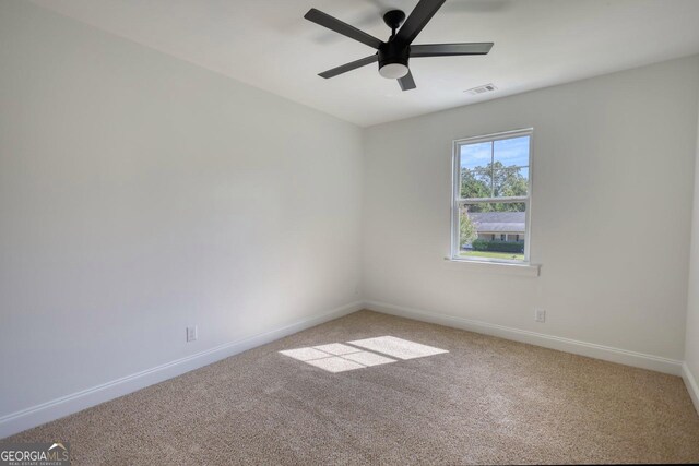 empty room featuring carpet floors and ceiling fan