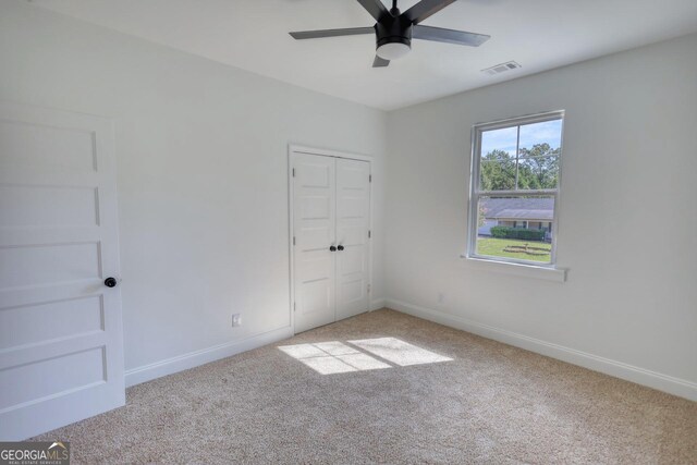 unfurnished bedroom with carpet floors, a closet, and ceiling fan