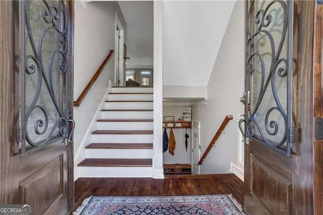 entrance foyer with vaulted ceiling and hardwood / wood-style flooring