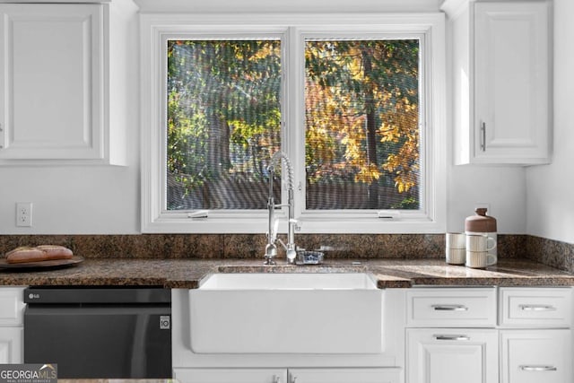 kitchen featuring dark stone countertops, dishwasher, white cabinets, and sink