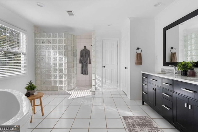 bathroom featuring tile patterned flooring, a tile shower, and vanity