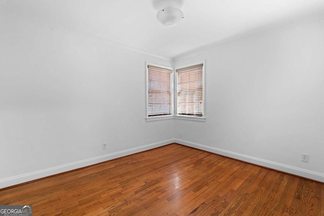 unfurnished room with hardwood / wood-style floors and ornamental molding