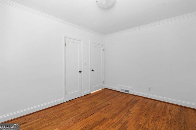 spare room featuring crown molding and wood-type flooring