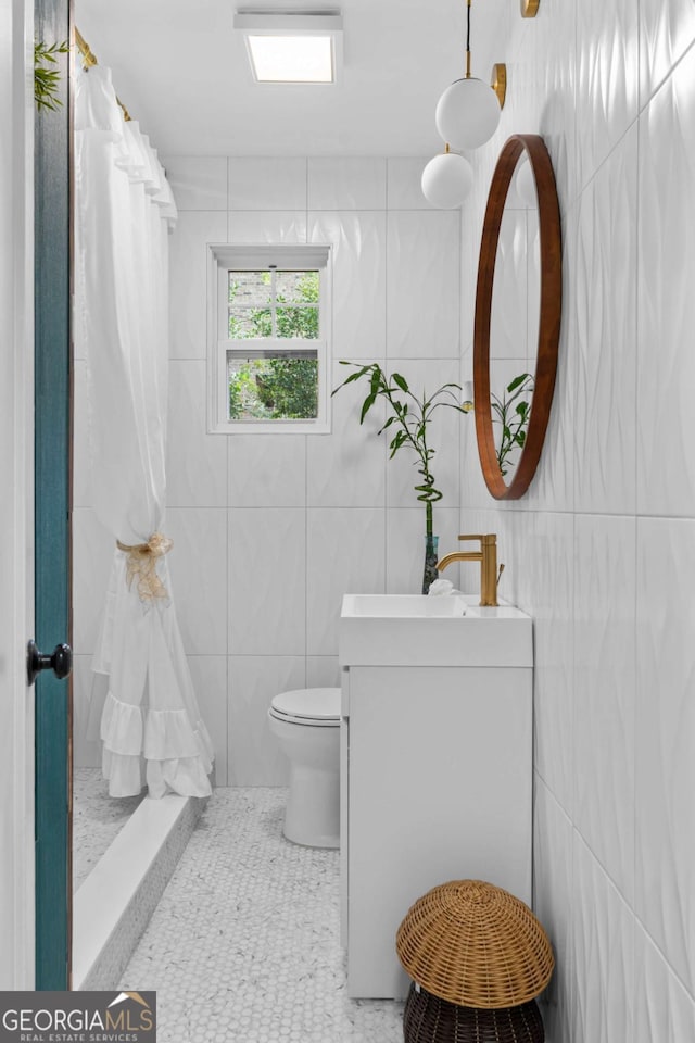 bathroom with tile patterned flooring, vanity, toilet, and walk in shower