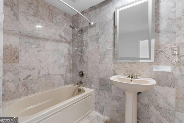 bathroom with tiled shower / bath and tile walls