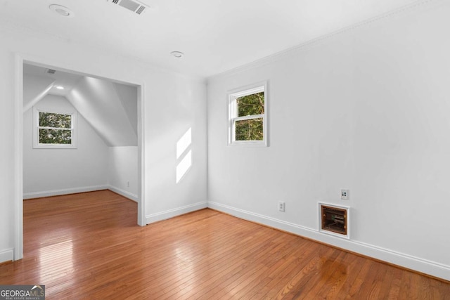 additional living space with hardwood / wood-style flooring, vaulted ceiling, and a healthy amount of sunlight