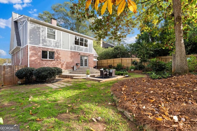 back of property with french doors, a patio area, and a lawn