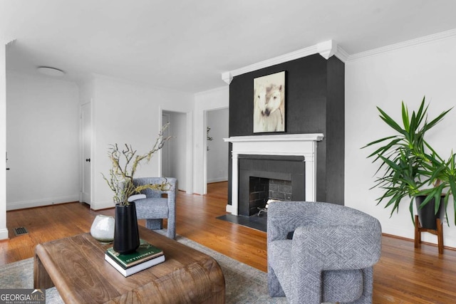 living room with wood-type flooring and crown molding