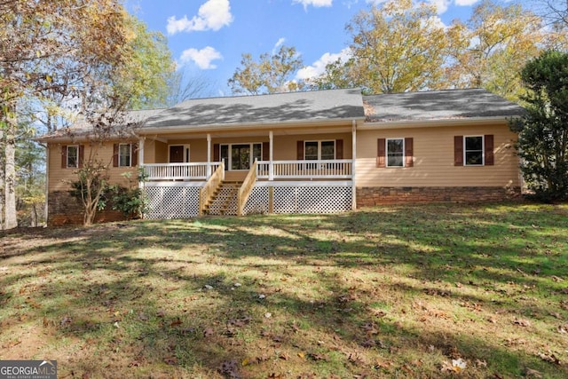 rear view of property with covered porch and a lawn