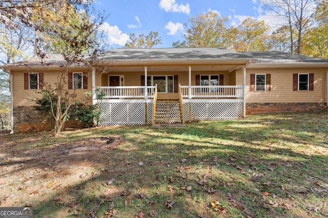 rear view of house with covered porch and a yard