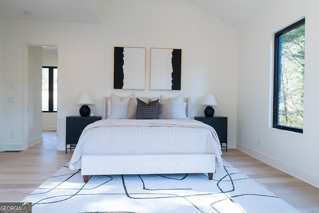 bedroom featuring multiple windows and light hardwood / wood-style flooring