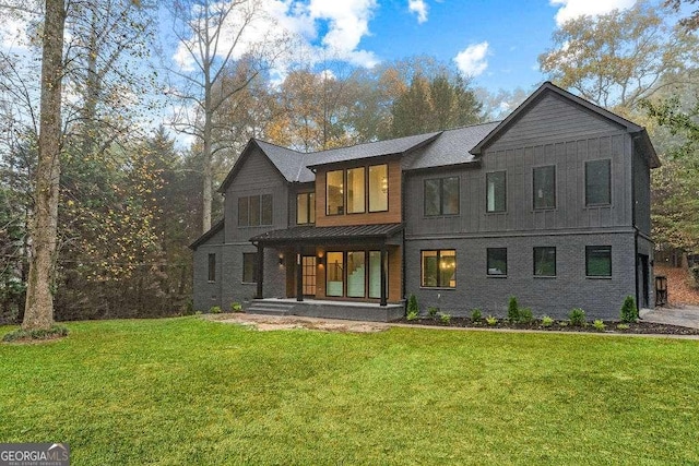 back of house featuring covered porch and a lawn