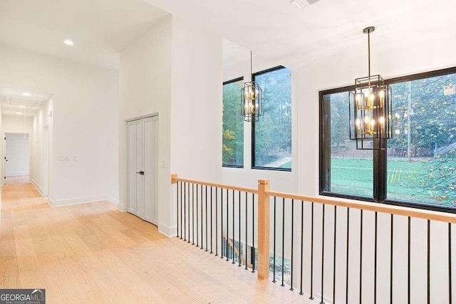 hall featuring an inviting chandelier and light hardwood / wood-style floors