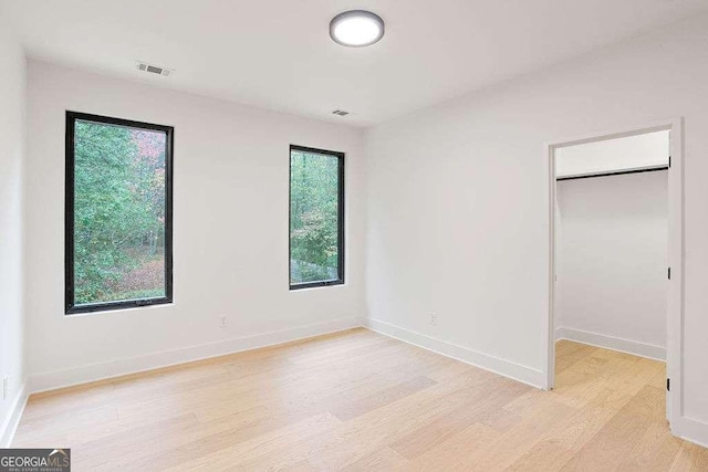 unfurnished bedroom with light hardwood / wood-style floors and a closet