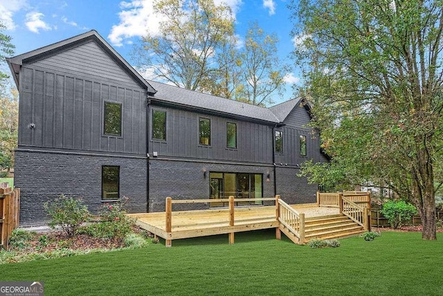 rear view of property featuring a wooden deck and a yard